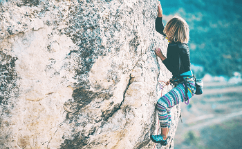 Woman climbing a cliff 