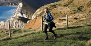 Female running a marathon along the Jurassic coastline